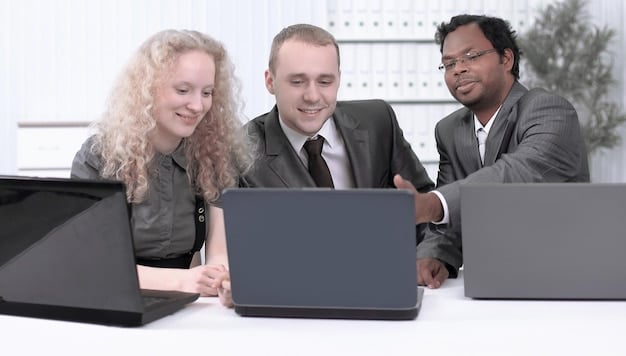 A photograph depicting a group of government employees collaborating on laptops within an office setting. The focus is on the teamwork and data analysis involved in improving the efficiency of social program delivery. The atmosphere is professional and dedicated, highlighting the efforts to enhance program management.