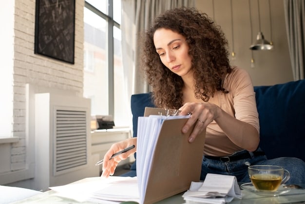 A person reviewing a stack of financial documents related to a mortgage application, including tax returns, bank statements, and income reports.
