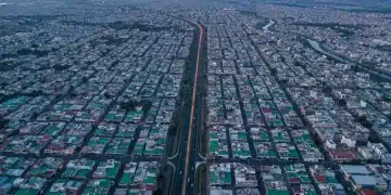 Vista aérea de una vasta ciudad mexicana al amanecer, mostrando la intrincada planificación urbana y las redes de calles que simbolizan la compleja trayectoria financiera de la planificación del retiro en México.