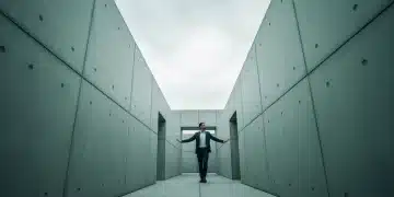 Una persona en la entrada de un laberinto de concreto verde, simbolizando la complejidad del mercado hipotecario mexicano y la toma de decisiones financieras.