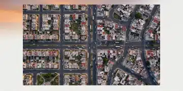 Vista aérea de un paisaje urbano mexicano al amanecer con autos moviéndose en patrones geométricos, simbolizando la movilidad y las oportunidades del financiamiento automotriz.